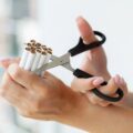 Stop smoking, woman cuts a cigarette with scissors